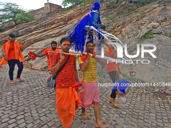 Kanwariyas are carrying holy water from the shrine 'Galta Peeth Tirtha' and going back to their pilgrimage in the auspicious month of 'Sharv...