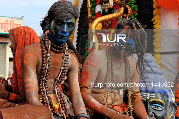 Jaipur: An artist is dressing up while kanwariyas are carrying holy water from the shrine 'Galta Peeth Tirtha' and going back to their pilgr...