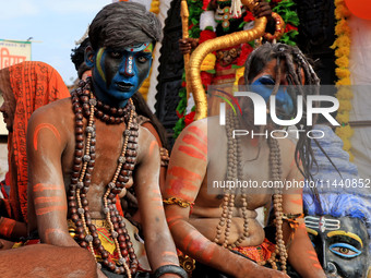 Jaipur: An artist is dressing up while kanwariyas are carrying holy water from the shrine 'Galta Peeth Tirtha' and going back to their pilgr...