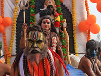 An artist is dressing up as Lord Shiva while kanwariyas are carrying holy water from the shrine 'Galta Peeth Tirtha' and going back to their...