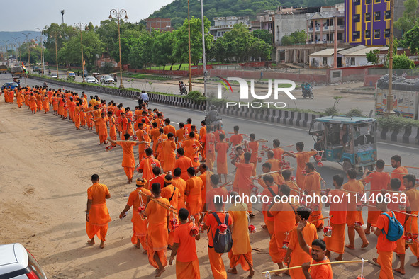 Kanwariyas are carrying holy water from the shrine 'Galta Peeth Tirtha' and going back to their pilgrimage in the auspicious month of 'Sharv...