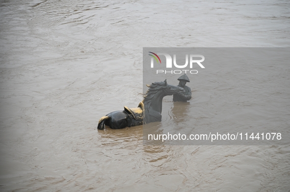 Bronze sculptures of horses and warriors are being seen submerged by floods at the Toudao wharf in Jilin City, Jilin province, China, on Jul...