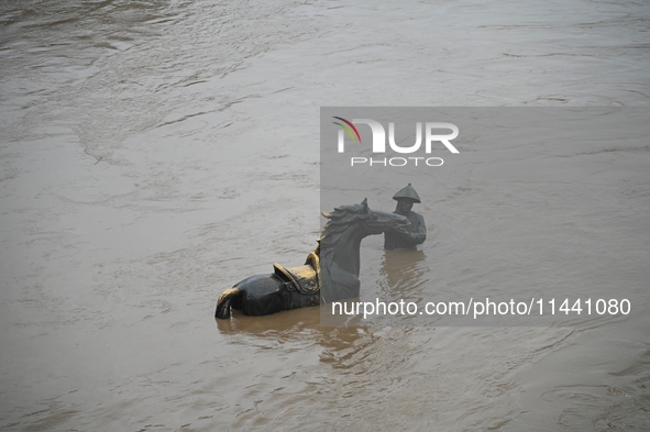 Bronze sculptures of horses and warriors are being seen submerged by floods at the Toudao wharf in Jilin City, Jilin province, China, on Jul...