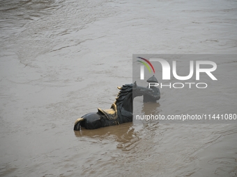 Bronze sculptures of horses and warriors are being seen submerged by floods at the Toudao wharf in Jilin City, Jilin province, China, on Jul...