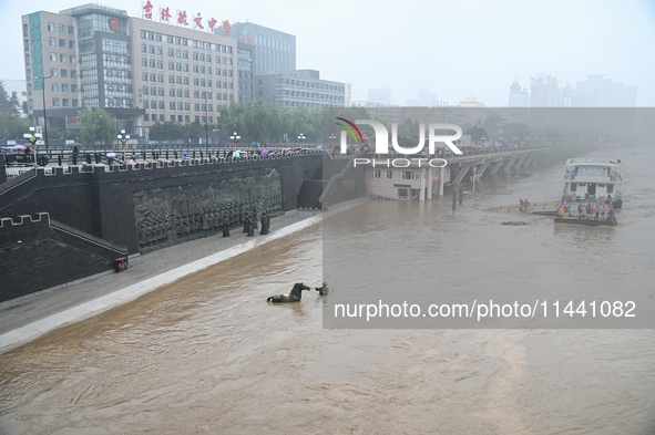 Bronze sculptures of horses and warriors are being seen submerged by floods at the Toudao wharf in Jilin City, Jilin province, China, on Jul...