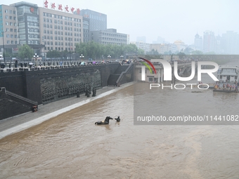 Bronze sculptures of horses and warriors are being seen submerged by floods at the Toudao wharf in Jilin City, Jilin province, China, on Jul...