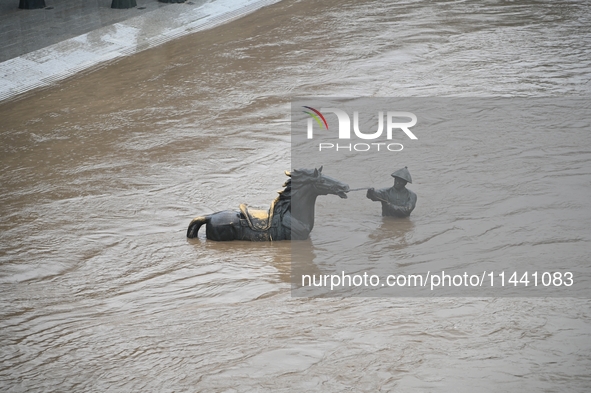 Bronze sculptures of horses and warriors are being seen submerged by floods at the Toudao wharf in Jilin City, Jilin province, China, on Jul...