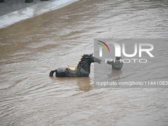 Bronze sculptures of horses and warriors are being seen submerged by floods at the Toudao wharf in Jilin City, Jilin province, China, on Jul...