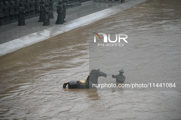 Bronze sculptures of horses and warriors are being seen submerged by floods at the Toudao wharf in Jilin City, Jilin province, China, on Jul...