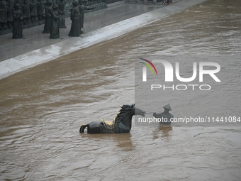 Bronze sculptures of horses and warriors are being seen submerged by floods at the Toudao wharf in Jilin City, Jilin province, China, on Jul...