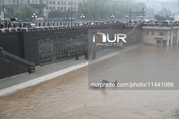 Bronze sculptures of horses and warriors are being seen submerged by floods at the Toudao wharf in Jilin City, Jilin province, China, on Jul...