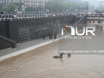 Bronze sculptures of horses and warriors are being seen submerged by floods at the Toudao wharf in Jilin City, Jilin province, China, on Jul...