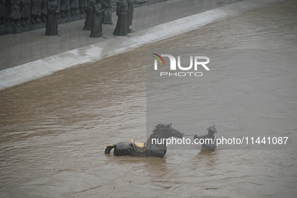 Bronze sculptures of horses and warriors are being seen submerged by floods at the Toudao wharf in Jilin City, Jilin province, China, on Jul...