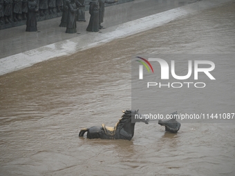 Bronze sculptures of horses and warriors are being seen submerged by floods at the Toudao wharf in Jilin City, Jilin province, China, on Jul...