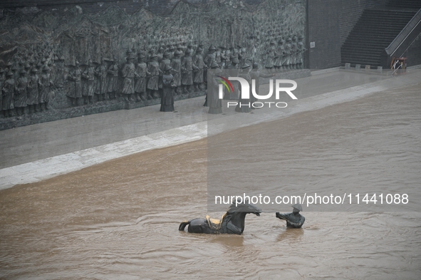 Bronze sculptures of horses and warriors are being seen submerged by floods at the Toudao wharf in Jilin City, Jilin province, China, on Jul...