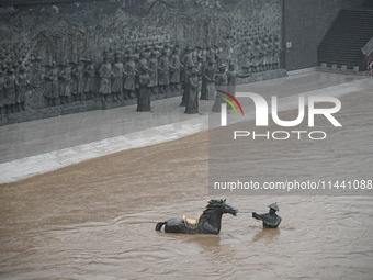 Bronze sculptures of horses and warriors are being seen submerged by floods at the Toudao wharf in Jilin City, Jilin province, China, on Jul...