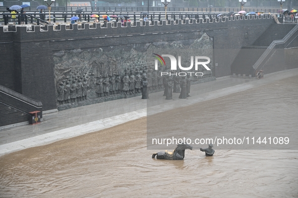 Bronze sculptures of horses and warriors are being seen submerged by floods at the Toudao wharf in Jilin City, Jilin province, China, on Jul...