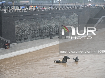 Bronze sculptures of horses and warriors are being seen submerged by floods at the Toudao wharf in Jilin City, Jilin province, China, on Jul...