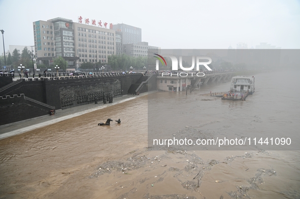 Bronze sculptures of horses and warriors are being seen submerged by floods at the Toudao wharf in Jilin City, Jilin province, China, on Jul...