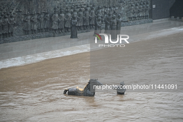 Bronze sculptures of horses and warriors are being seen submerged by floods at the Toudao wharf in Jilin City, Jilin province, China, on Jul...