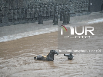 Bronze sculptures of horses and warriors are being seen submerged by floods at the Toudao wharf in Jilin City, Jilin province, China, on Jul...