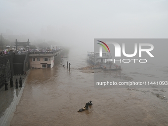 Bronze sculptures of horses and warriors are being seen submerged by floods at the Toudao wharf in Jilin City, Jilin province, China, on Jul...