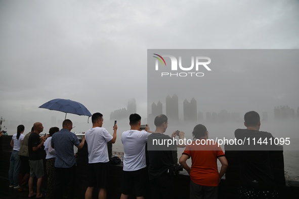 Citizens are watching the rising water at the Toudao wharf in Jilin City, Jilin province, China, on July 28, 2024. 