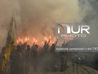 Servicemen of the Azov battalion are lighting flares as they attend a ceremony to remember the victims of the Olenivka camp explosion, in Ky...