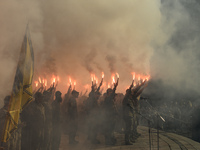 Servicemen of the Azov battalion are lighting flares as they attend a ceremony to remember the victims of the Olenivka camp explosion, in Ky...