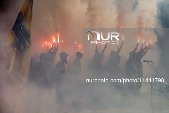 Servicemen of the Azov battalion are lighting flares as they attend a ceremony to remember the victims of the Olenivka camp explosion, in Ky...