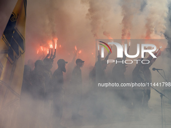 Servicemen of the Azov battalion are lighting flares as they attend a ceremony to remember the victims of the Olenivka camp explosion, in Ky...