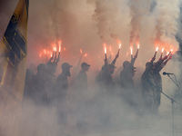 Servicemen of the Azov battalion are lighting flares as they attend a ceremony to remember the victims of the Olenivka camp explosion, in Ky...