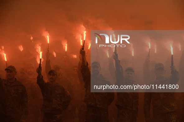 Servicemen of the Azov battalion are lighting flares as they attend a ceremony to remember the victims of the Olenivka camp explosion, in Ky...