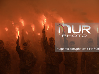 Servicemen of the Azov battalion are lighting flares as they attend a ceremony to remember the victims of the Olenivka camp explosion, in Ky...