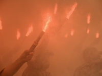 Servicemen of the Azov battalion are lighting flares as they attend a ceremony to remember the victims of the Olenivka camp explosion, in Ky...