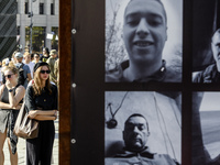 People are reacting as they are attending a ceremony to remember the victims of the Olenivka camp explosion, in Kyiv, Ukraine, on July 28, 2...