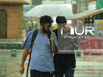 People are walking along a street as it is raining in Srinagar, Jammu and Kashmir, on July 29, 2024. (