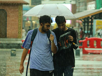 People are walking along a street as it is raining in Srinagar, Jammu and Kashmir, on July 29, 2024. (