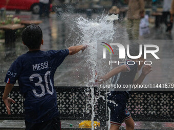 Children are playing with fountain water as it is raining in Srinagar, Jammu and Kashmir, on July 29, 2024. (