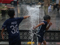 Children are playing with fountain water as it is raining in Srinagar, Jammu and Kashmir, on July 29, 2024. (