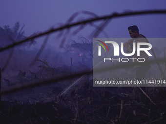 Indonesian police officers are trying to extinguish a peatland fire in the palm oil plantation area of Company Permata Hijau Indonesia in Pa...