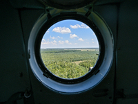 A landscape is being seen through a porthole of a Mi-8MSB-V assault transport helicopter of the 16th Brody Separate Army Aviation Brigade in...