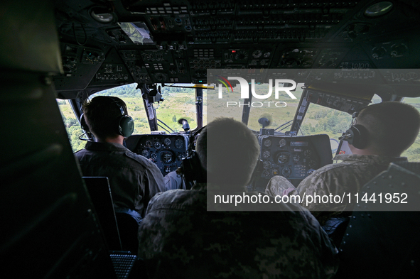 Crew members are in the cockpit of a Mi-8MSB-V assault transport helicopter of the 16th Brody Separate Army Aviation Brigade in Ukraine, on...