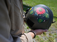 A flight engineer of a Mi-8MSB-V assault transport helicopter of the 16th Brody Separate Army Aviation Brigade is showing his painted flight...