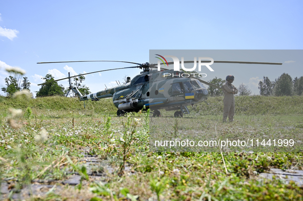 A flight engineer is standing by a Mi-8MSB-V assault transport helicopter of the 16th Brody Separate Army Aviation Brigade in Ukraine, on Ju...