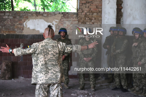 A Shkval (Squall) Battalion serviceman sporting an oseledets hairstyle is facing other soldiers in Ukraine, on July 26, 2024. Former prisone...