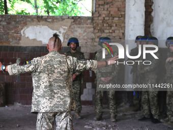 A Shkval (Squall) Battalion serviceman sporting an oseledets hairstyle is facing other soldiers in Ukraine, on July 26, 2024. Former prisone...