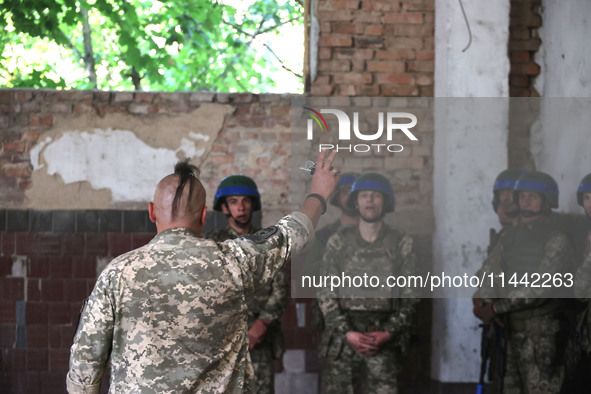 A Shkval (Squall) Battalion serviceman with an oseledets hairstyle is facing other soldiers in Ukraine, on July 26, 2024. Former prisoners w...