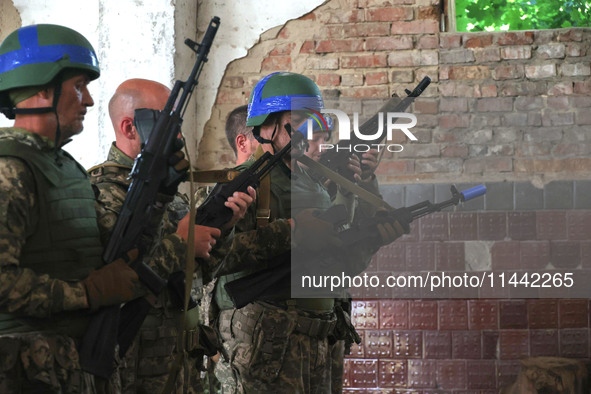 The Shkval (Squall) Battalion servicemen are holding rifles during drills in Ukraine, on July 26, 2024. Former prisoners who volunteered to...