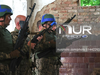 The Shkval (Squall) Battalion servicemen are holding rifles during drills in Ukraine, on July 26, 2024. Former prisoners who volunteered to...